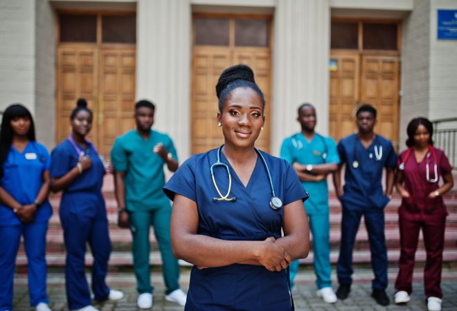 Group of african medical students posed outdoor against university door.