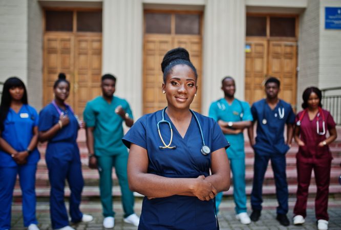 Group of african medical students posed outdoor against university door.