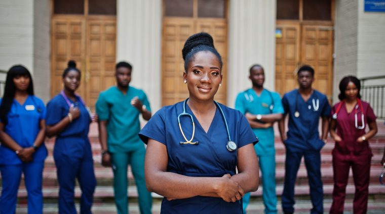 Group of african medical students posed outdoor against university door.